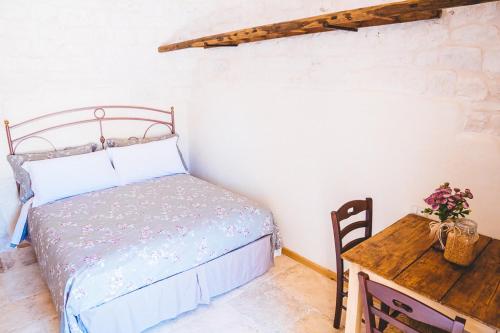 a bedroom with a bed and a wooden table at Materiis in Noci