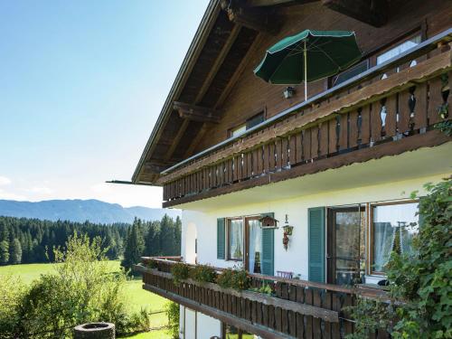 Cette maison dispose d'un balcon avec un parasol. dans l'établissement Apartment in Reitersau near the ski area, à Steingaden