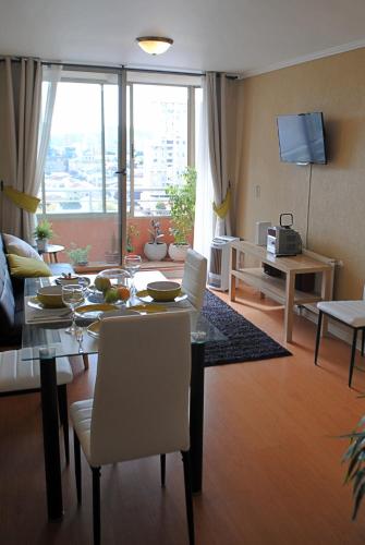 a living room with a table and chairs and a living room at EcoApart Concepción in Concepción