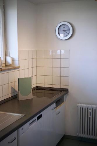 a small kitchen with a clock on the wall at FeWo SeeLeben in Bodman-Ludwigshafen
