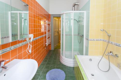La salle de bains est pourvue d'une baignoire, d'un lavabo et d'une douche. dans l'établissement Andrews Centre Apartment, à Prague