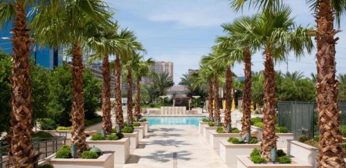 a row of palm trees next to a swimming pool at Penthouse Suite with Strip View at The Signature At MGM Grand in Las Vegas