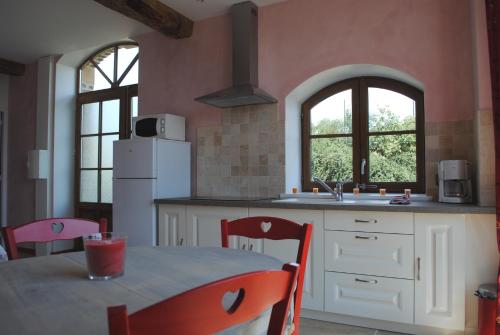 a kitchen with a table with chairs and a sink at Domaine de la Poyat in Légny
