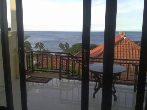 a room with a view of the ocean from a balcony at Sinar Bali 2 in Amed