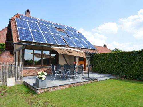 una casa con paneles solares en el techo en With a broad view over the hilly landscape, en Flobecq