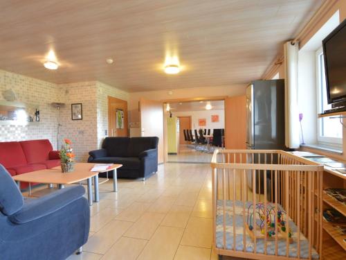 sala de estar con sofás, mesa y cocina en Spacious Apartment in Gr fflingen with Sauna, en Burg-Reuland