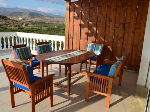 a wooden table and four chairs on a patio at Beautiful spacious villa near Makry Gialos in Makry Gialos