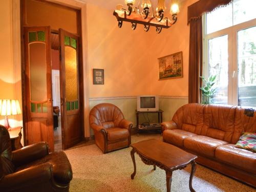 sala de estar con muebles de cuero y TV en This plain house is very suitable for groups, en Ferrières