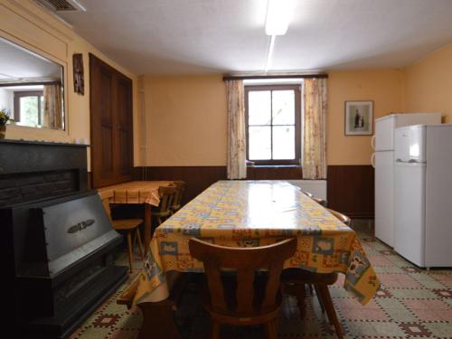 comedor con mesa y nevera en This plain house is very suitable for groups, en Ferrières