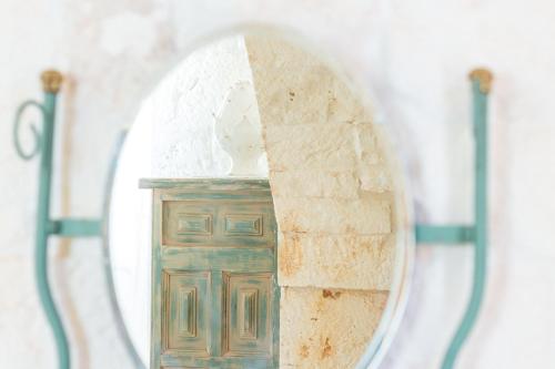 a mirror on a wall with a wooden cabinet at Materiis in Noci