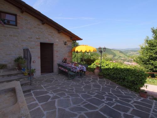 ApecchioにあるStone Cottage in Marche with Swimming Poolのパティオ(テーブル、傘付)