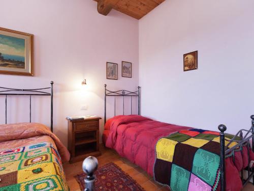 a bedroom with two beds and a table with a night stand at Cottage in Marche near Ski Slopes in Apecchio
