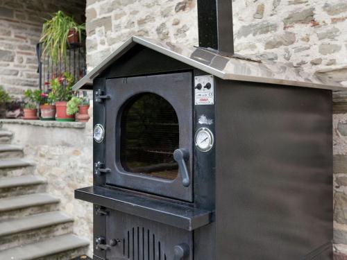 a black oven sitting next to a brick building at Cottage in Marche near Ski Slopes in Apecchio