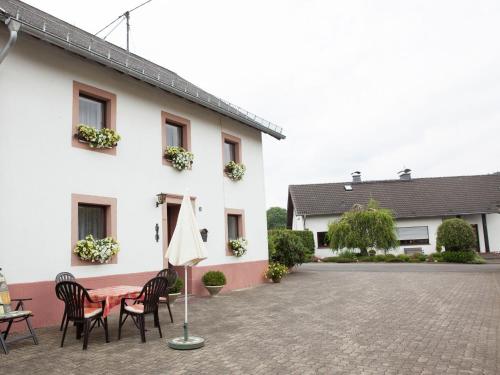 a patio with a table and chairs and an umbrella at Enjoy a holiday on the farm in a quiet area in Sellerich