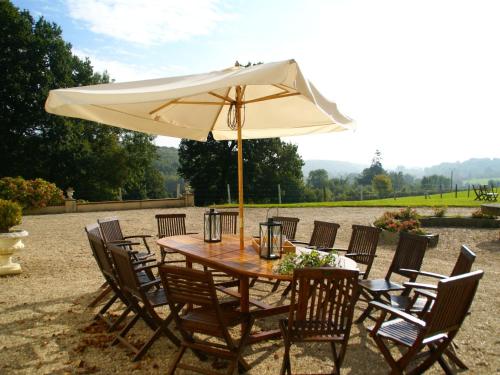 a table and chairs with a large umbrella at Heritage Castle in Asni res with Garden in Asnières