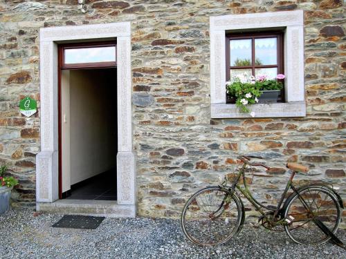 a bike parked next to a stone building with two windows at Attractive apartment in Jehonville with terrace in Jehonville