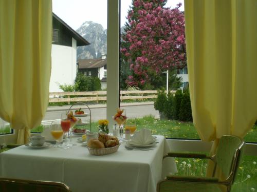 a white table with a bowl of food and a window at Hotel Christine in Füssen