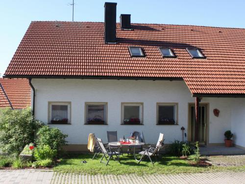 ein Haus mit einem Tisch und Stühlen davor in der Unterkunft Spacious holiday home in Neureichenau Schimmelbach in Neureichenau