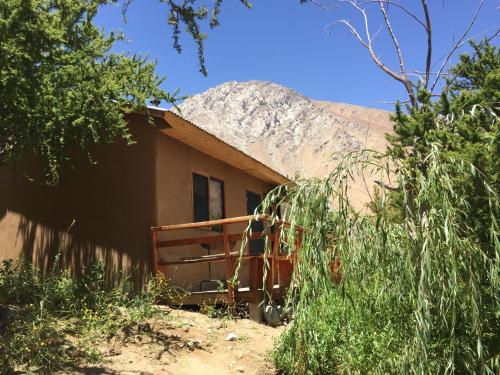 a small house with a thatched roof in the desert at Cabañas Luna de Cuarzo, Cochiguaz in Paihuano