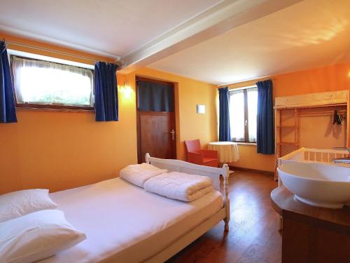a bedroom with a bed and a sink in it at Ecologically renovated former farmhouse in Wellin