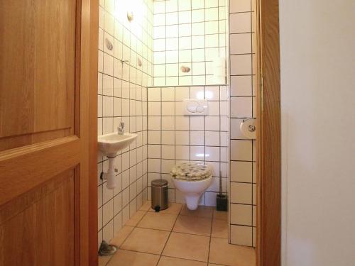 a small bathroom with a toilet and a sink at Ecologically renovated former farmhouse in Wellin