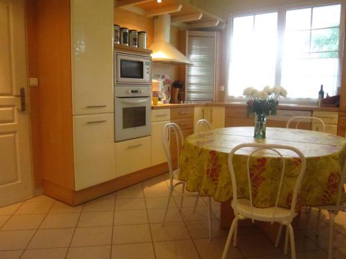 una cocina con una mesa con un jarrón de flores. en Superb holiday home in Escalles near the sea, en Escalles