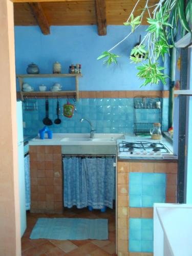 a kitchen with a sink and a stove at Case Vacanze Fossanave in Santa Tecla