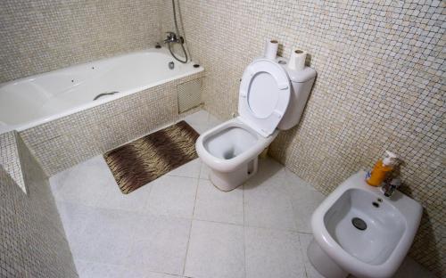 a bathroom with a toilet and a tub and a bidet at Umbrella Holidays l 1Bd room l in Dcheira El Jihadia