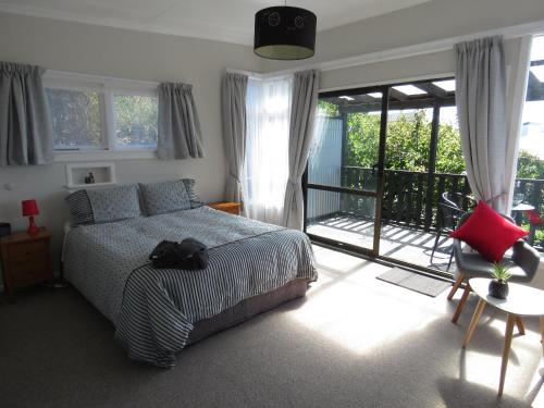 a bedroom with a bed and a balcony at Oamaru Harbour Nest in Oamaru