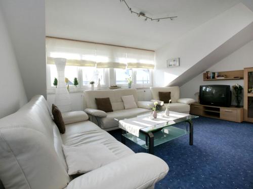 a living room with white couches and a tv at Apartment in Dietmannsried near the forest in Dietmannsried