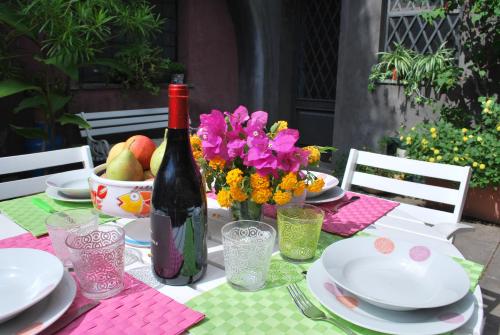 a table with a bottle of wine and flowers on it at Case Vacanze Fossanave in Santa Tecla