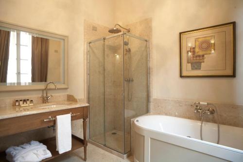a bathroom with a tub, sink and mirror at Palazzo Righini in Fossano