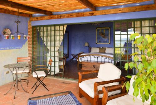 a room with a bed and a chair and a table at Hotel Casa Palopo in Santa Catarina Palopó