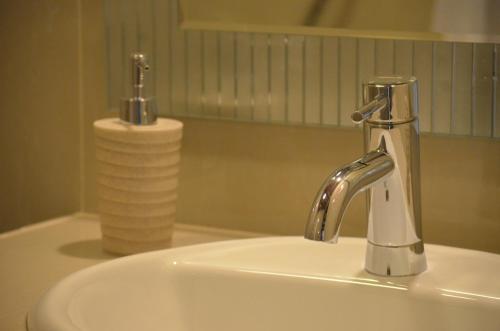 a bathroom sink with a faucet and a roll of paper towels at Casa de Campo Santa Rosa in Cajamarca