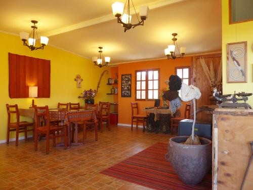 a dining room with yellow walls and a table and chairs at Terrace Lodge in Putre