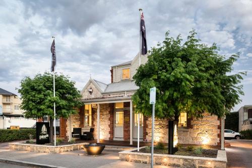 a building with two flags in front of it at Pier 21 Riverside Apartment Hotel in Fremantle