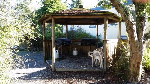 a wooden gazebo with a table and chairs at Fairlie Holiday Park in Fairlie