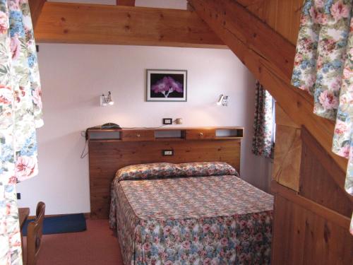 a bedroom with a bed in a room with a staircase at Hotel Petit Giles in Cogne