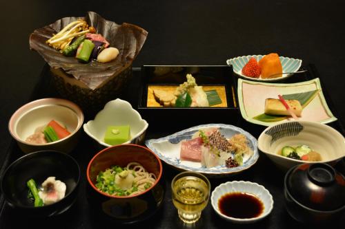 a table topped with different types of food in bowls at Shiunso in Hakone