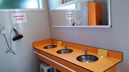 a bathroom with two sinks and a mirror at Fairlie Holiday Park in Fairlie