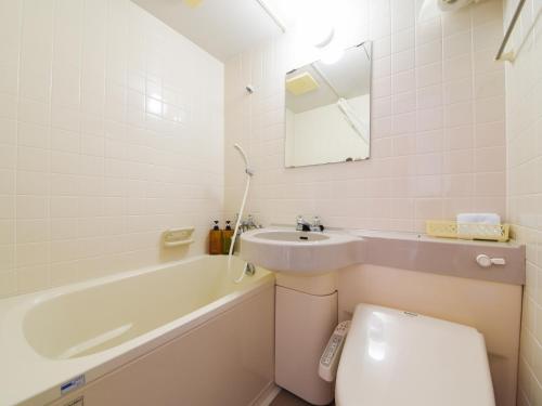 a white bathroom with a sink and a toilet at Pension Hoshinosuna in Iriomote