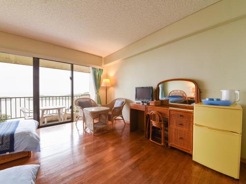 1 dormitorio con cama y escritorio con espejo en Pension Hoshinosuna, en Iriomote