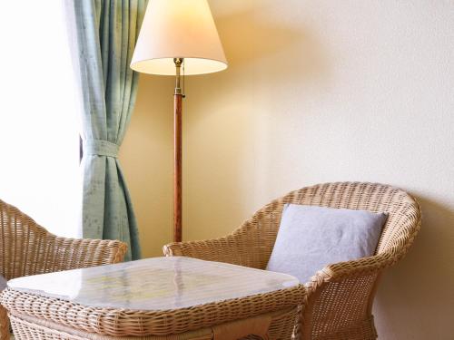 a room with a table and chairs and a lamp at Pension Hoshinosuna in Iriomote