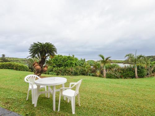 a white table and chairs on a grass field at Pension Hoshinosuna in Iriomote