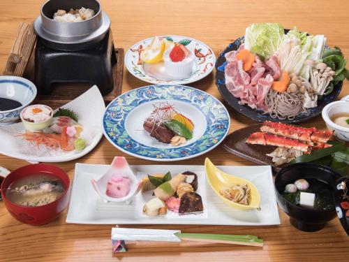 a wooden table with plates of food on it at Tokiwaso in Miyakonozyō