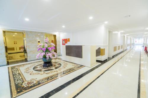 a hallway with a vase of flowers on the floor at Tan An Palace in Hai Phong
