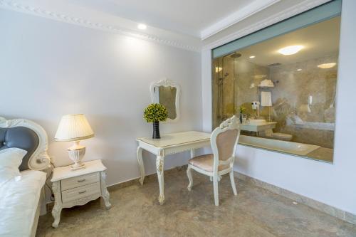 a bedroom with a bed and a desk with a mirror at Tan An Palace in Hai Phong