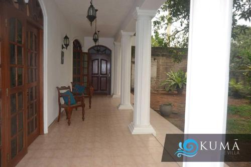 a hallway of a house with a door and chairs at Kuma Beach side Villa in Wadduwa