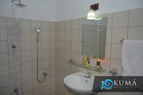 a bathroom with a sink and a mirror at Kuma Beach side Villa in Wadduwa