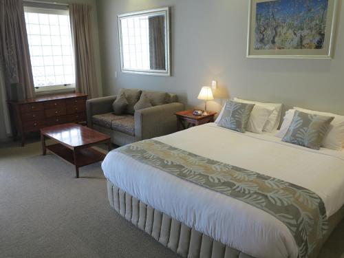a hotel room with a large bed and a couch at Shangri-La Gardens in Brisbane